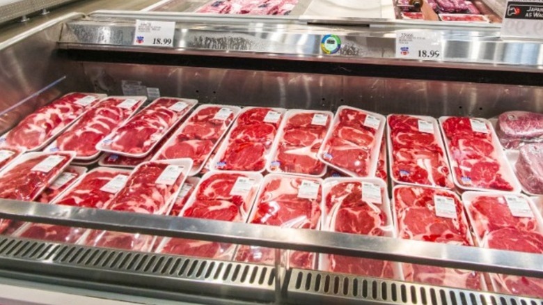 Filas de carnes envasadas en el congelador de un supermercado