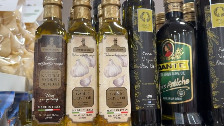 Surtido de botellas de aceite de oliva en un estante de vidrio