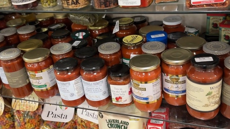 Frascos de salsas para pastas rojas en un estante de vidrio