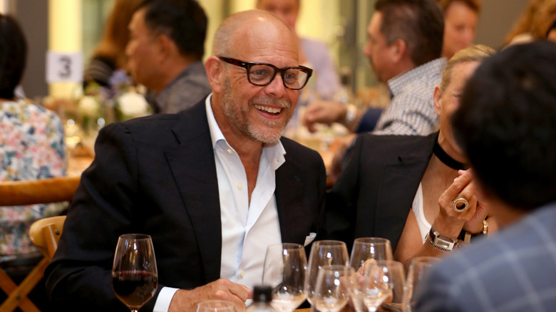 Alton Brown sonriendo en una mesa