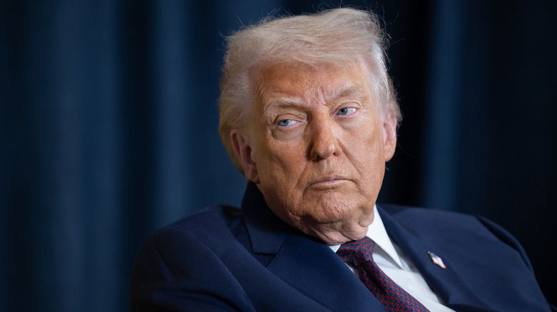 Donald Trump frente a cortinas azules