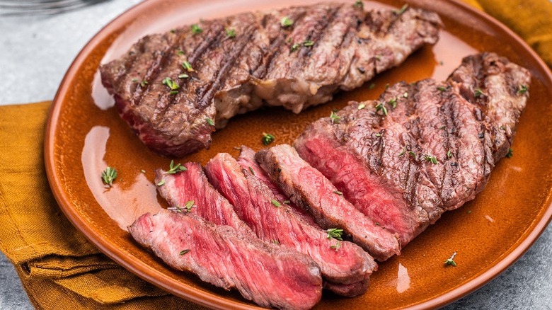 Dos trozos de filete a la plancha, uno de ellos cortado en rodajas