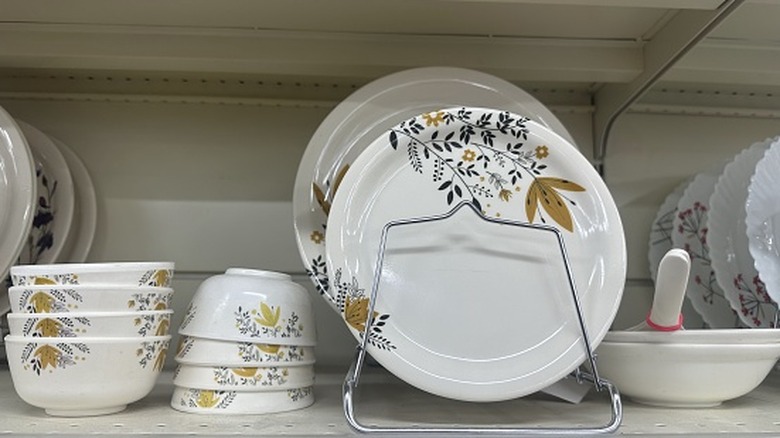 Platos antiguos alineados junto a tazones apilados en un estante