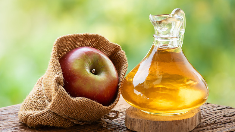 Jarra de vinagre de manzana con manzanas frescas