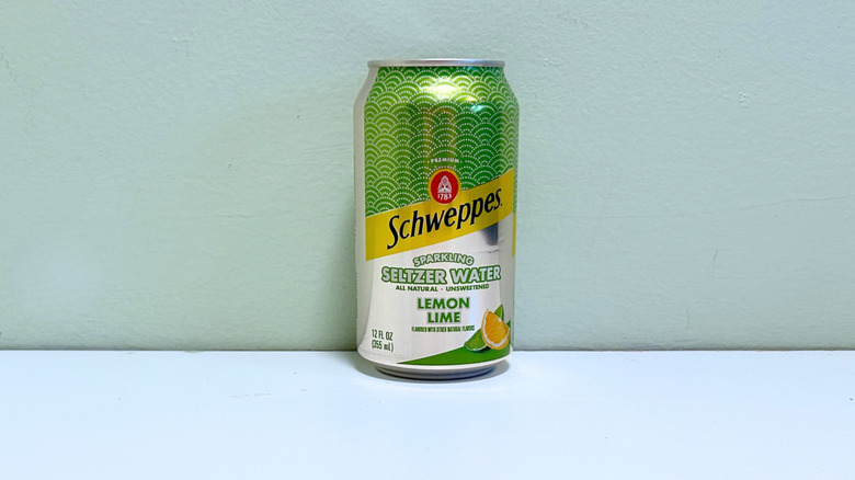 Una lata de agua mineral con gas Schweppes, lima y limón