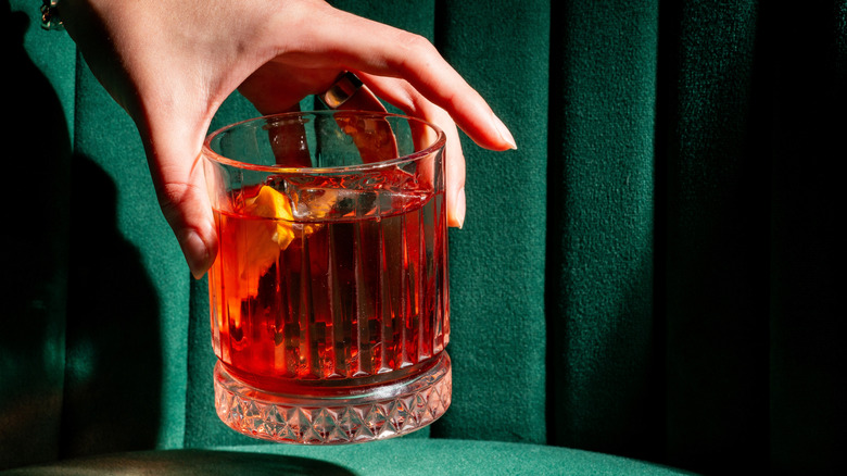 Cóctel Negroni con fondo verde