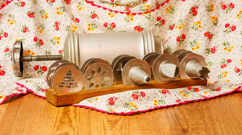 Prensa de galletas vintage con un delantal al fondo