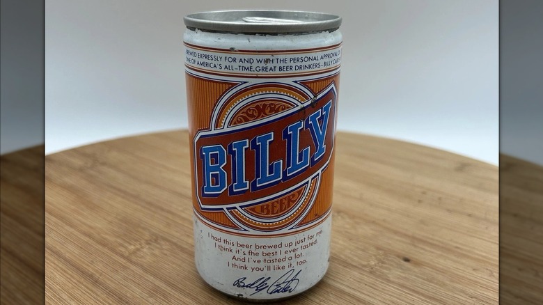 Una lata de cerveza Billy con un logotipo rojo, azul y naranja con detalles blancos y la firma de Billy Carter.