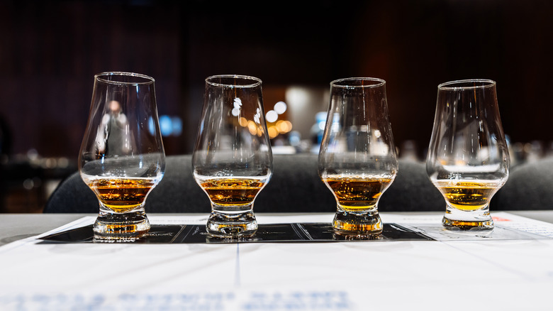 4 vasos en forma de tulipán alineados llenos de licor