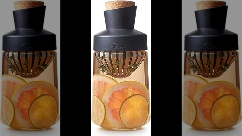 Infusor de licor de conejo con líquido, rodajas de cítricos y hierbas en su interior