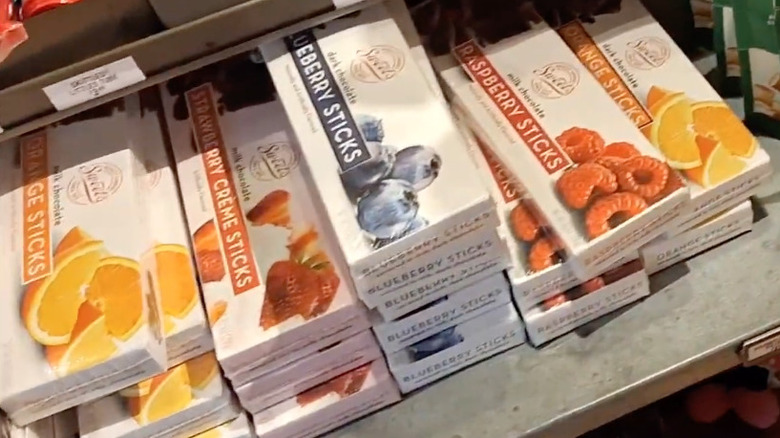 Cajas de dulces palitos de chocolate en arándanos, frambuesas, fresas y naranjas.