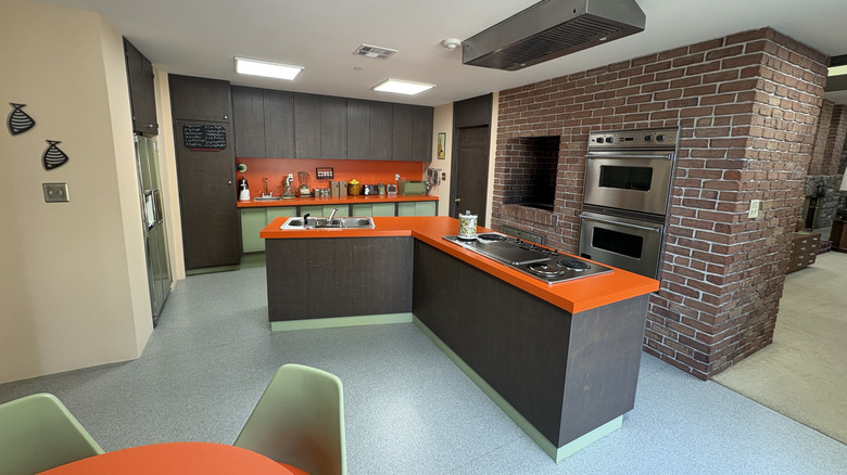Una toma amplia de la cocina de Brady Bunch con la mesa del comedor en primer plano.