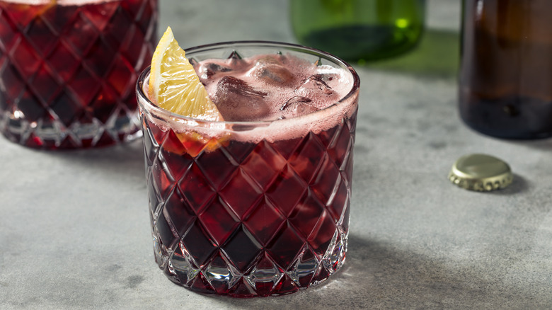 Cóctel kalimotxo con rodaja de limón en vaso bajo