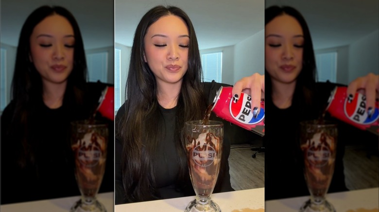 Mujer Pepsi en una fuente de vidrio con bebida marrón