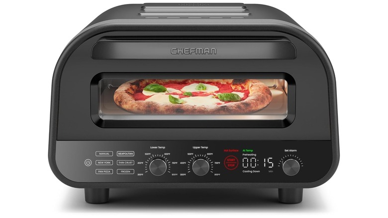Un horno de pizza interior CHEFMAN negro con pizza de espinacas y mozzarella en su interior
