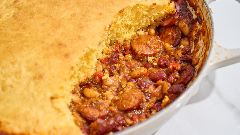 cazuela de gorro y salchicha en una sartén con cobertura de pan de maíz