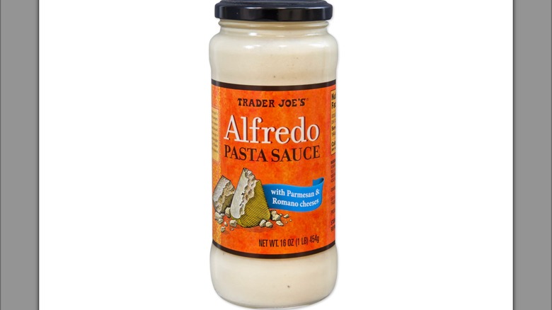 Un frasco de Trader Joes Alfredo con un fondo blanco.