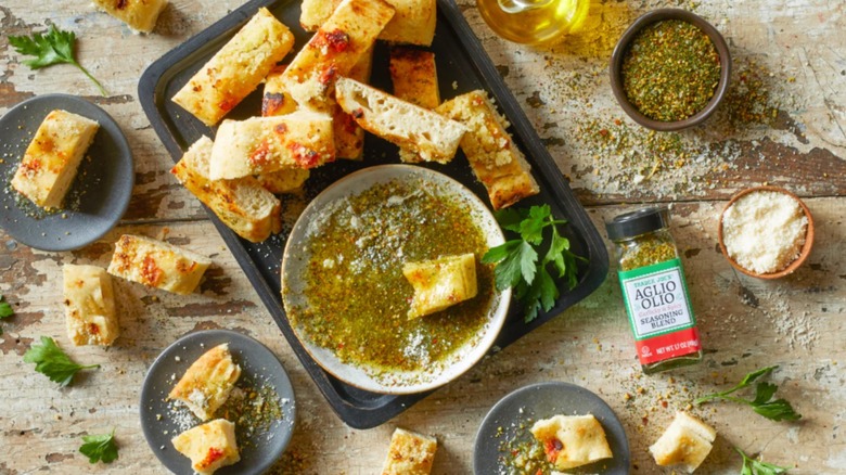 Mezcla de condimentos picantes y con ajo olio Trade Joes Aglio con un plato de baguette tostado y aceite para mojar en el centro