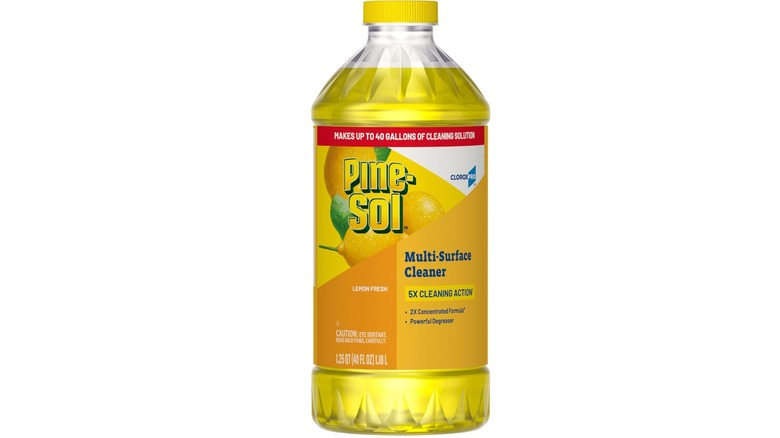 Botella de limpiador multisuperficie Pine-Sol con aroma a limón, etiqueta amarilla y fondo blanco.