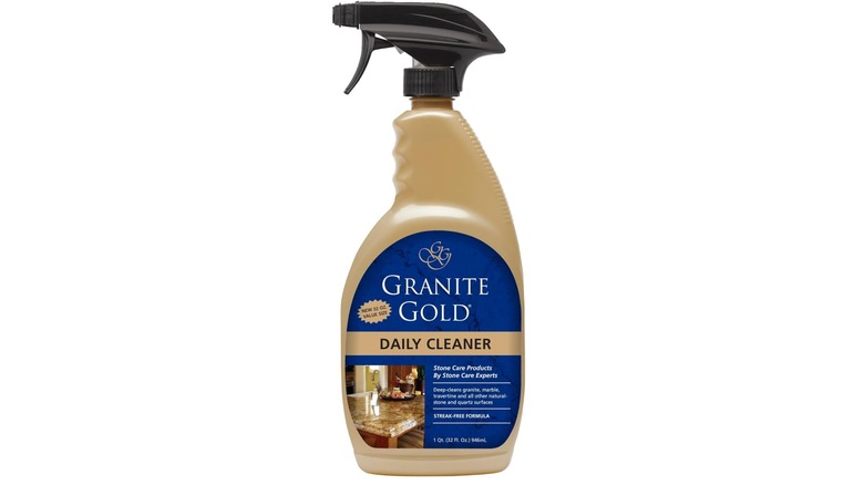Botella dorada de Granite Gold Daily Cleaner con etiqueta azul y fondo blanco.