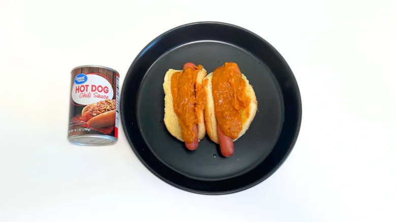 Salsa de chile para hot dog de gran valor junto a un plato negro con dos hot dogs y salsa