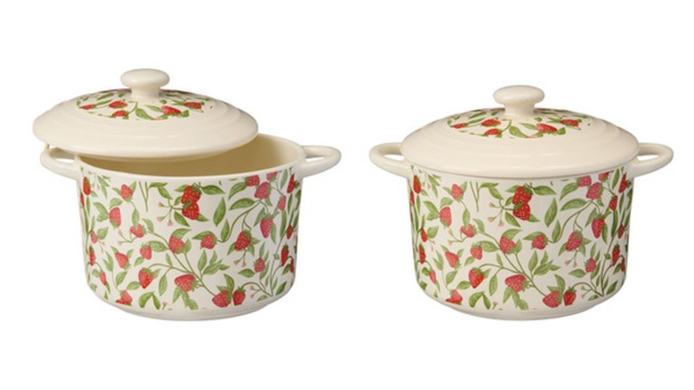 Dos mini moldes para hornear redondos de color crema con tapa, decorados con un estampado de fresas