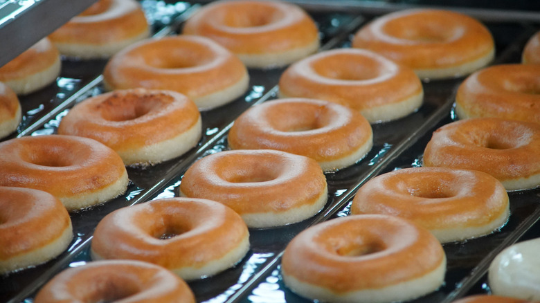 Krispy Kreme Original Glazed donuts rodando por una línea de montaje