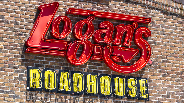 Señal de neón exterior roja y amarilla de Logan's Roadhouse a la luz del día