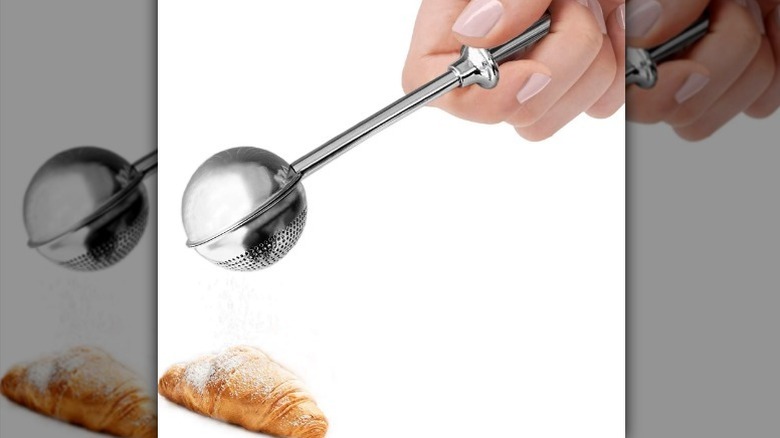 Coctelera de azúcar en polvo sobre fondo blanco.