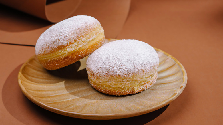 Donuts con azúcar en polvo en un plato marrón