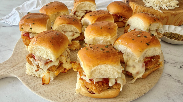 Deslizadores de pollo a la parmesana servidos sobre tabla de madera
