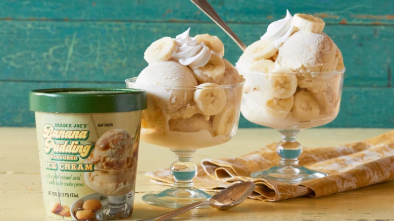 Tarrina de helado de pudín de plátano junto a dos platos de helado con nata y plátanos