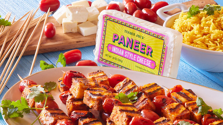 Bloque de paneer junto a cubos de paneer crudos y asados