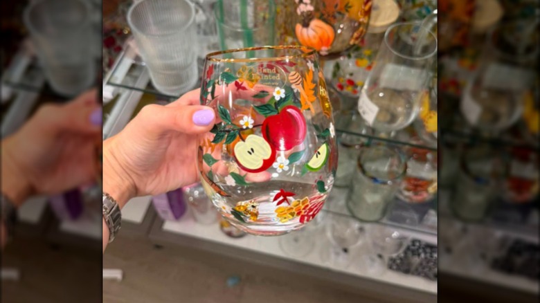 Copa de vino sin tallo pintada con manzanas en el frente