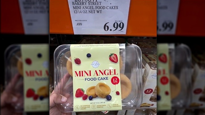 Mano sosteniendo un recipiente de mini pasteles de ángel.