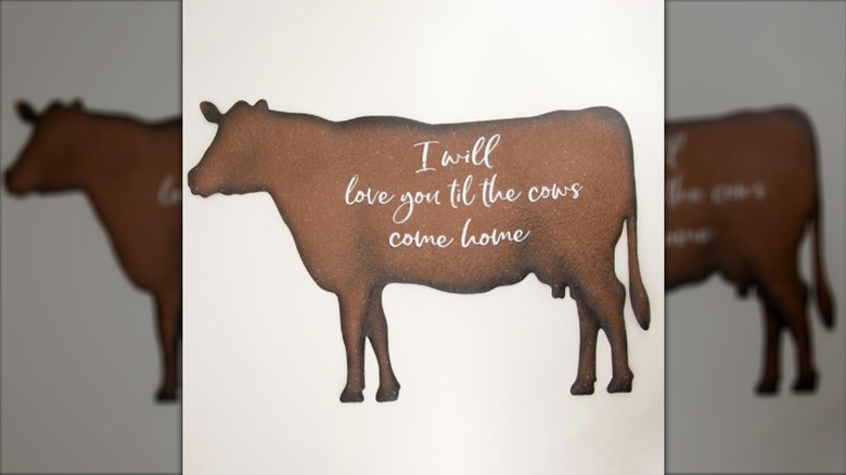 Decoración de pared de vaca de metal de una vaca marrón con escritura