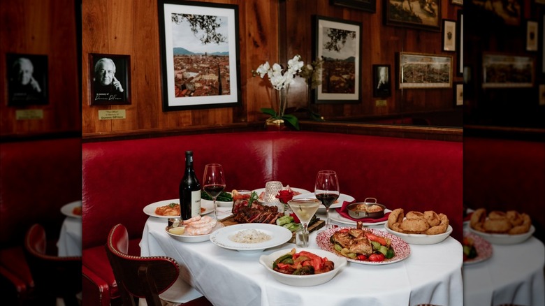 El stand favorito de Frank Sinatra en Gene & Georgetti con una variedad de platos del menú y vino en la mesa