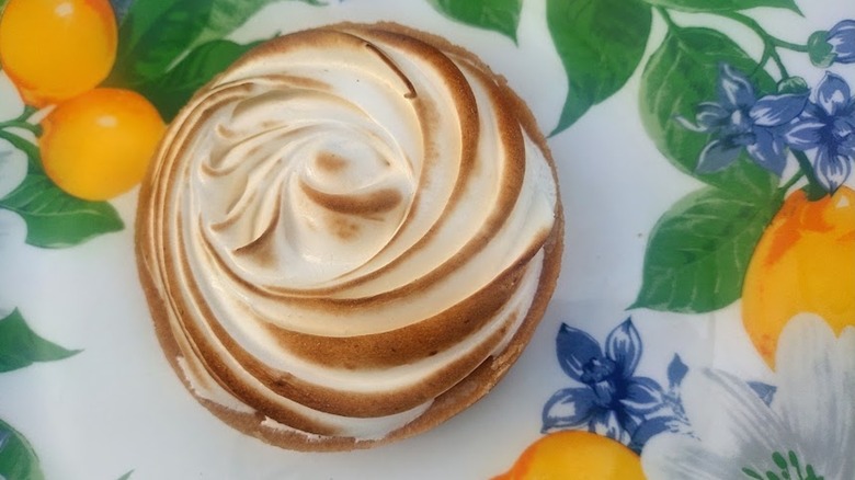 tartaletas de merengue de limón entero y medio en un plato con estampado de limón