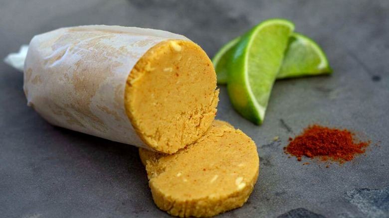 Mantequilla de miso y lima envuelta y cortada junto con rodajas de lima y condimentos