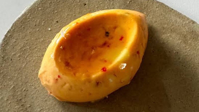 Una pequeña porción de mantequilla de chile y arce con el arce agrupado en el centro