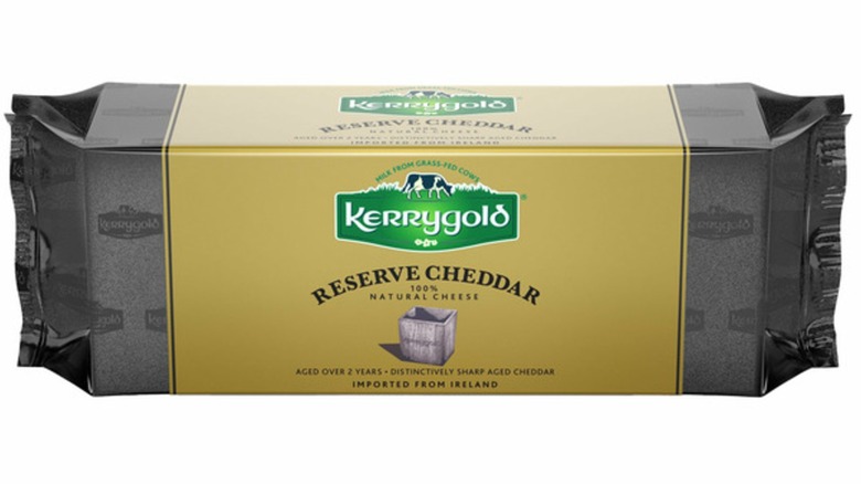 Bloque envuelto de Kerrygold Reserve Cheddar sobre fondo blanco.