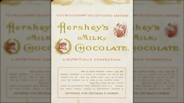 Envoltorio original de barra de chocolate de Hershey con un querubín, una vaca y un texto dorado.