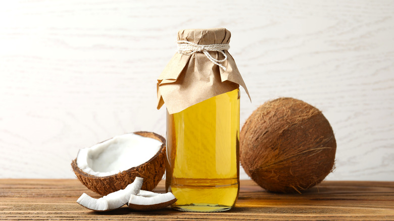 Botella de aceite de oliva con cocos en el mostrador.