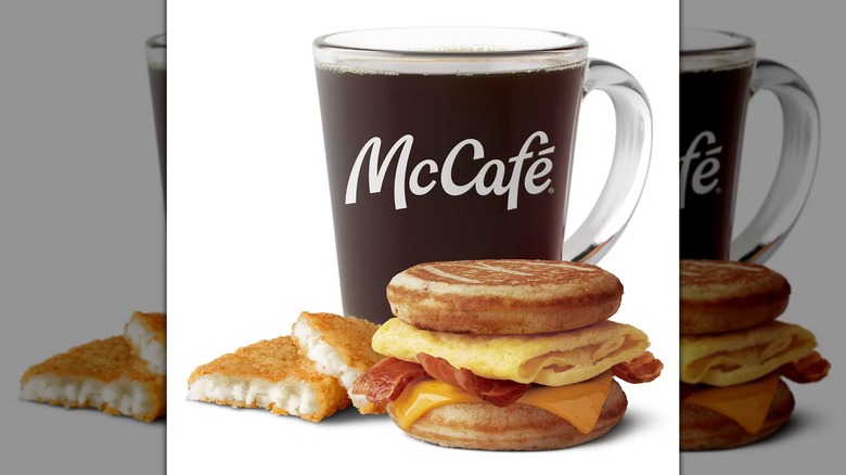 McDonald's McGriddle con croquetas de patata y un café McCafé sobre un fondo blanco.