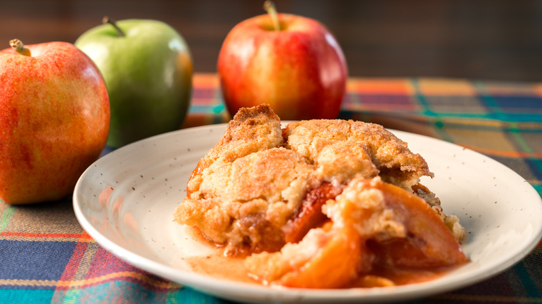 Zapatero de manzana plateado junto a manzanas.