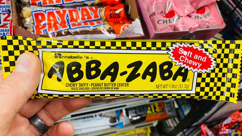 Persona sosteniendo una barra de chocolate Abba Zaba en una tienda