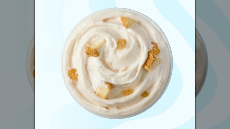 Un Dairy Queen Caramel Apple Cheesecake Blizzard sobre un fondo azul rayado