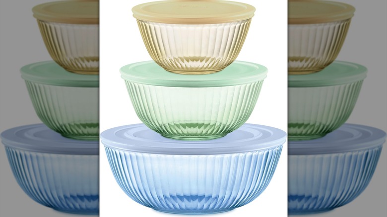 Pyrex Colors cuencos esculpidos y teñidos con tapas sobre un fondo blanco