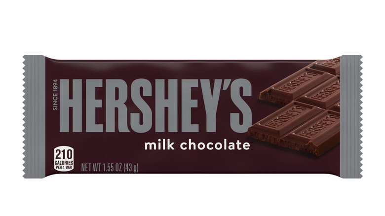 Barra de chocolate con leche Hershey con una envoltura marrón sobre fondo blanco.