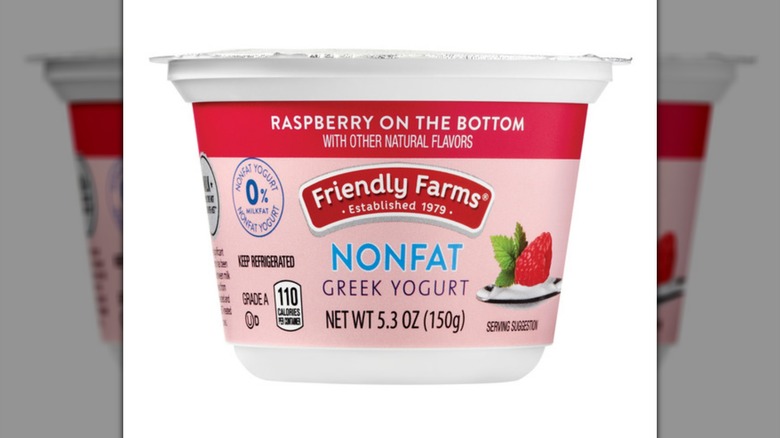 Yogur griego sin grasa Aldi's Friendly Farms con frambuesa sobre fondo blanco